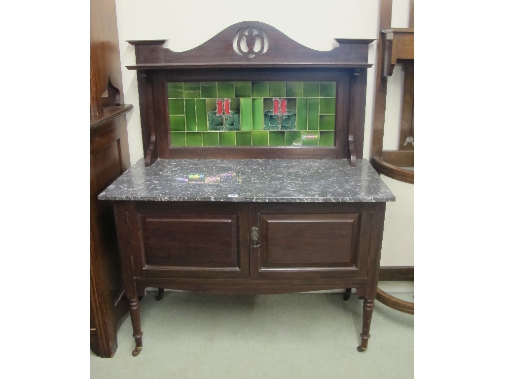 Appraisal: An Art Nouveau mahogany washstand with a tiled back and