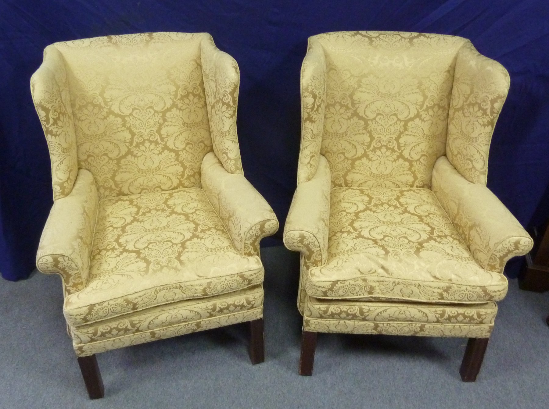 Appraisal: A pair of wing back armchairs on square chamfered legs