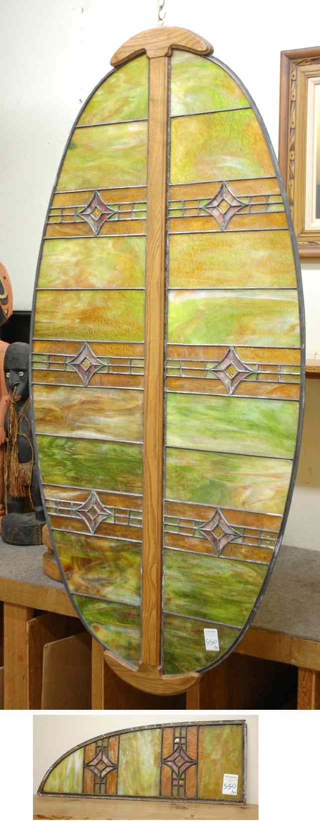 Appraisal: TWO PIECES STAINED AND LEADED GLASS PANELS an elliptical-shaped panel