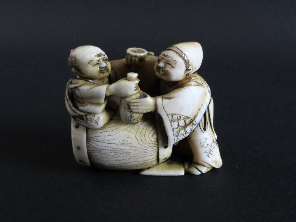 Appraisal: A Japanese carved ivory netsuke with a figure seated on