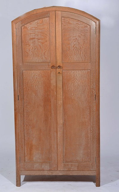 Appraisal: A HEALS LIMED OAK WARDROBE with domed top two panelled