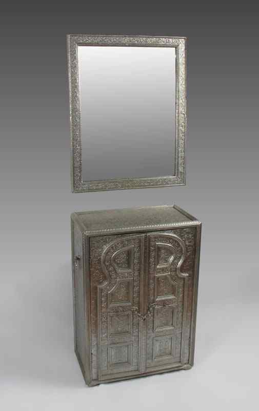 Appraisal: PERSIAN EMBOSSED METAL CABINET AND MIRROR door cabinet with recessed