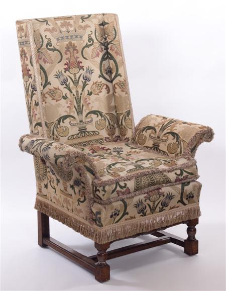 Appraisal: A Jacobean style wing chair with shallow wings over scroll