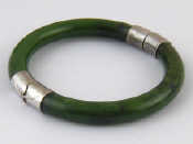 Appraisal: A nephrite bangle with white metal mounts approx cm internal