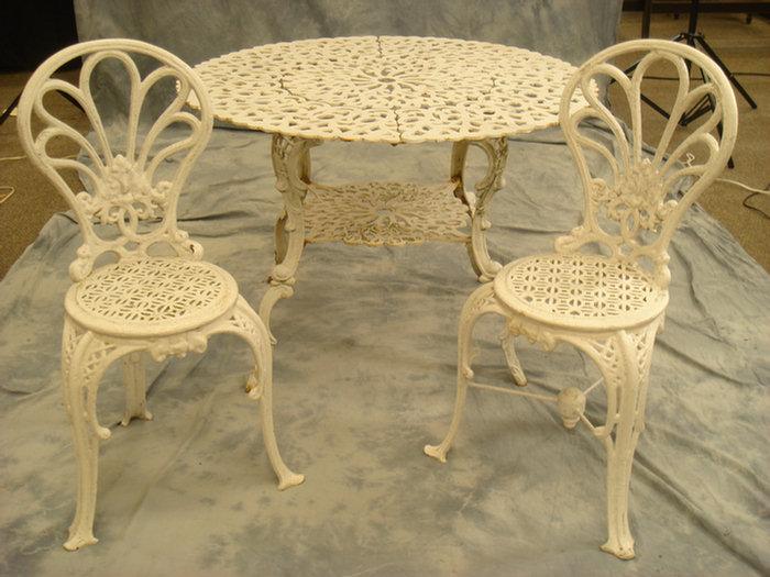 Appraisal: Cast iron patio table with two fanback chairs table d