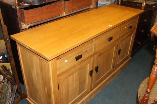 Appraisal: A MODERN LIGHT OAK SIDEBOARD fitted an arrangement of cupboards