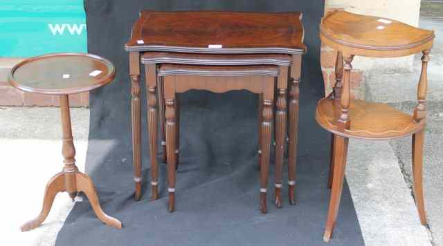 Appraisal: A REPRODUCTION NEST OF MAHOGANY TABLES on fluted supports with