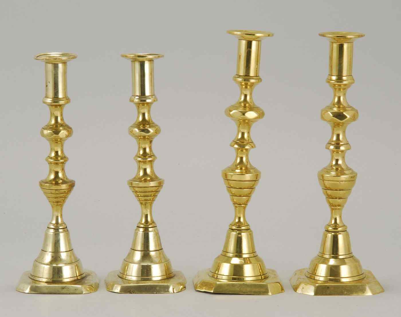 Appraisal: TWO PAIRS OF BRASS PUSH-UP CANDLESTICKSIn beehive and diamond pattern