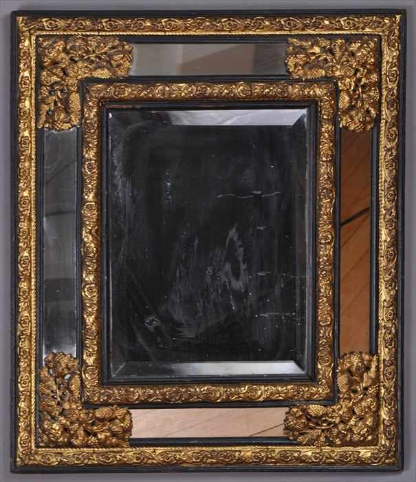 Appraisal: FLEMISH BAROQUE-STYLE REPOUSS BRASS AND BLACK STAINED WOOD MIRROR The