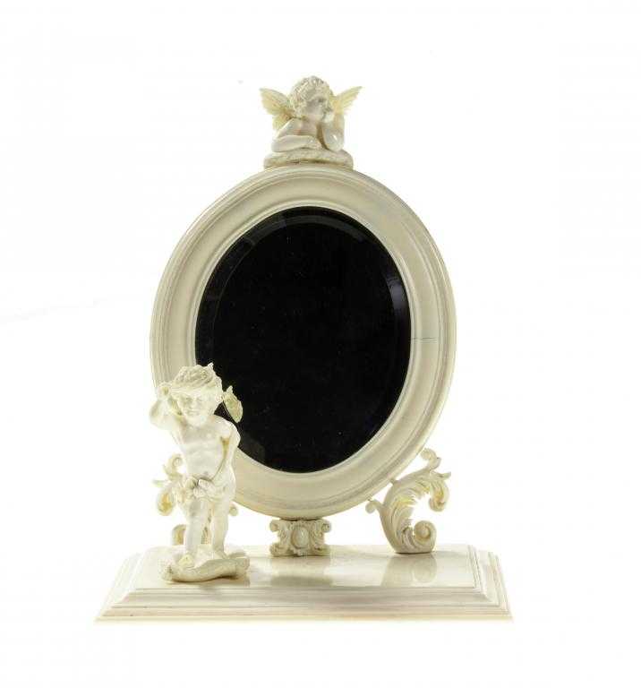 Appraisal: AN IVORY DRESSING MIRROR PROBABLY FRENCH the oval frame crested