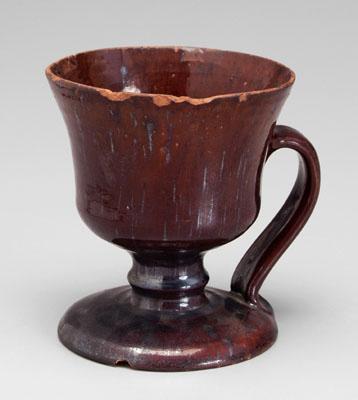 Appraisal: Footed redware mug runny brown glaze handle attaches from side