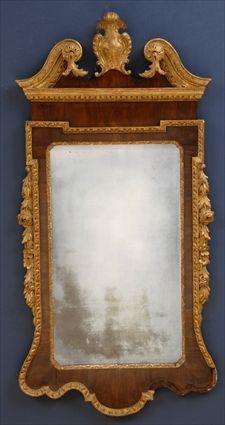 Appraisal: GEORGE II MAHOGANY AND PARCEL-GILT MIRROR The swan-neck cresting flanking