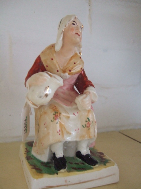 Appraisal: A th century Staffordshire figure of a lady sitting pouring