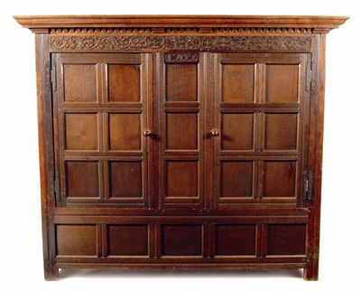 Appraisal: An oak wardrobe the moulded cornice above a leaf carved