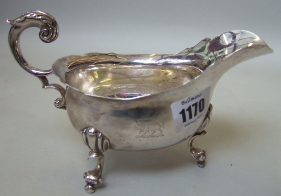 Appraisal: An Irish silver sauceboat with a shaped rim scrolling handle