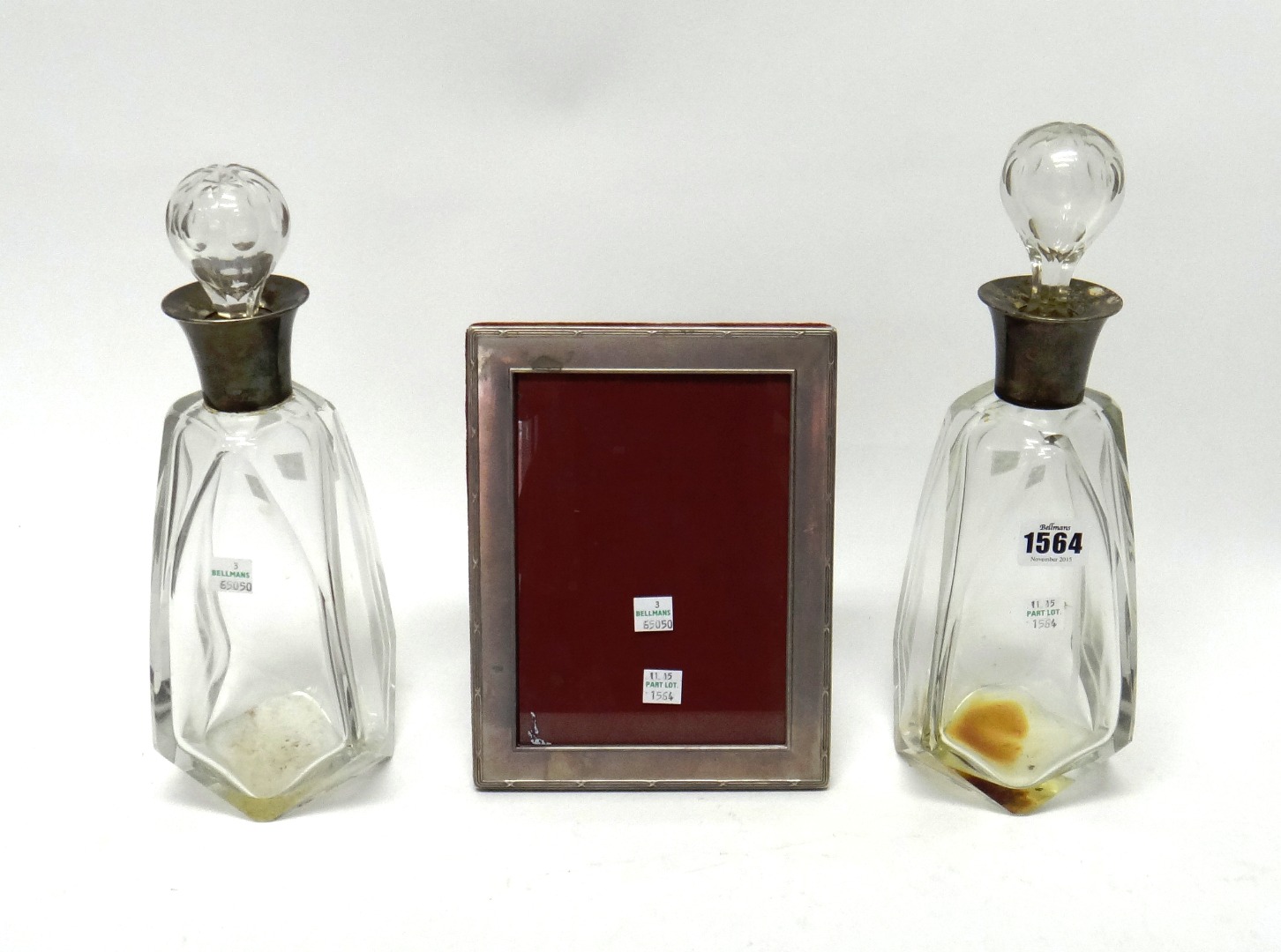 Appraisal: A pair of silver mounted faceted glass decanters in an