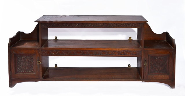 Appraisal: A CARVED WALNUT WALL SHELF in the style of Shapland