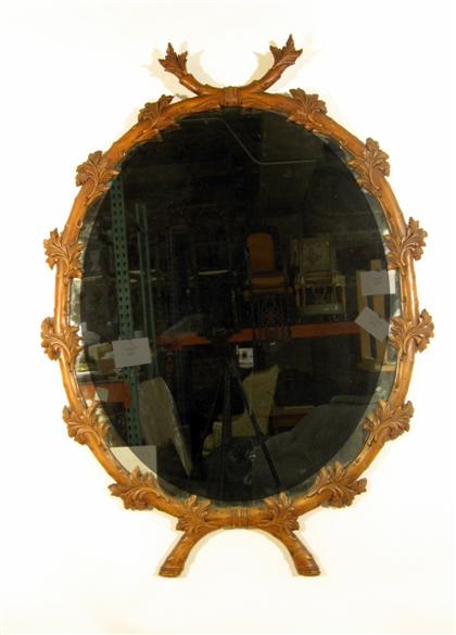 Appraisal: English carved pine mirror th century The oval frame naturalistically