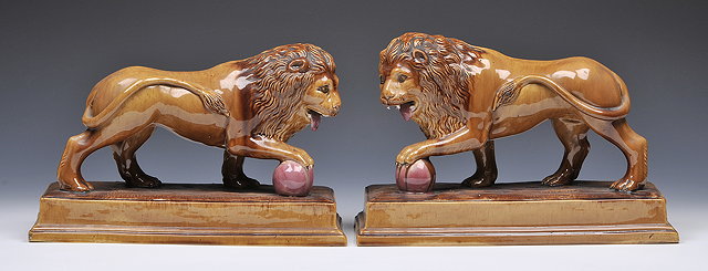 Appraisal: A PAIR OF GLAZED POTTERY LIONS each impressed George Skey