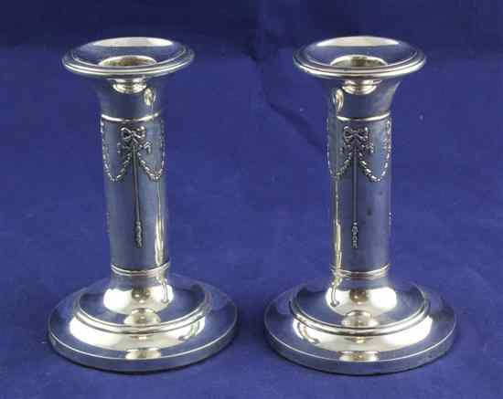 Appraisal: A pair of Edwardian silver dwarf candlesticks embossed with ribbon