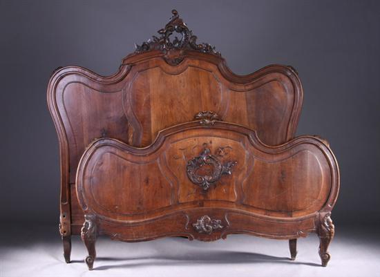 Appraisal: FRENCH ROCOCO-STYLE CARVED FRUITWOOD BED late th century Crested triple-lobed