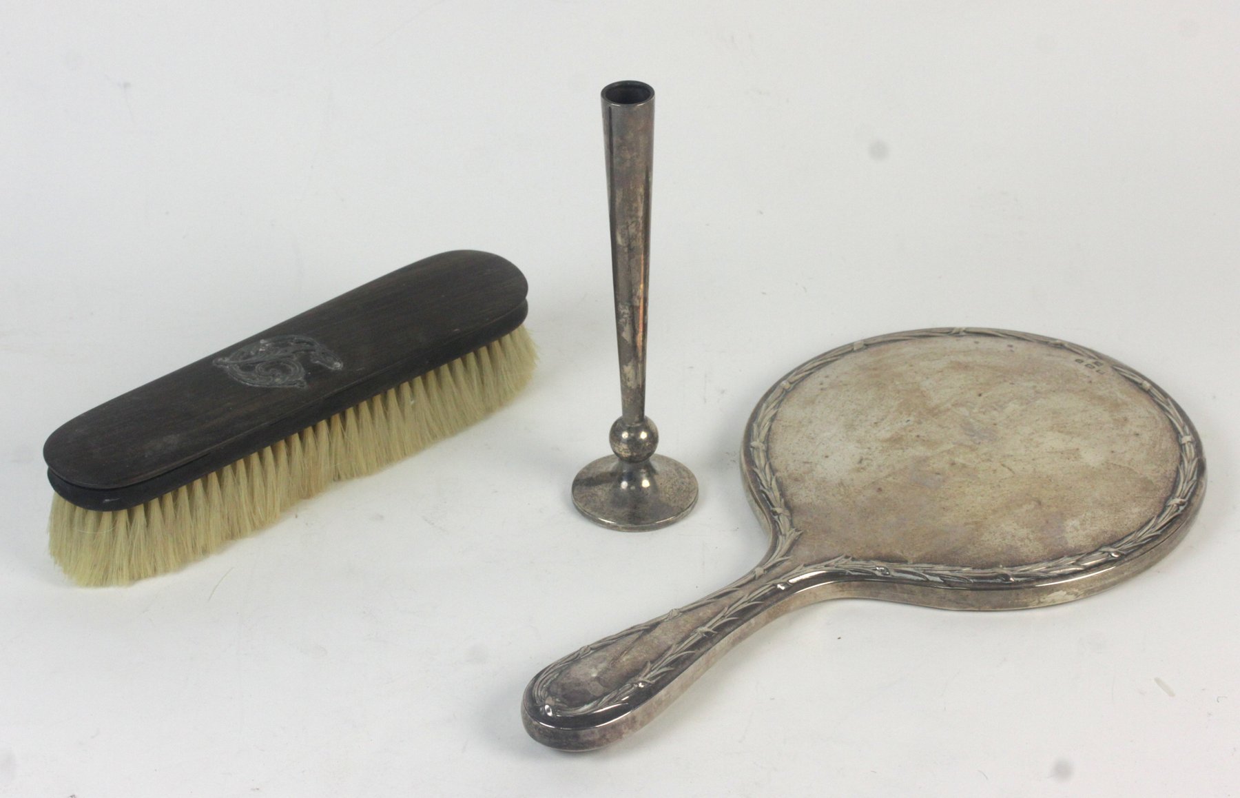 Appraisal: A silver-backed hand mirror with wreath embossed border Martin Hall