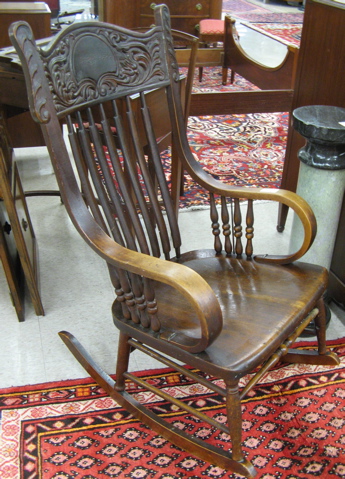 Appraisal: LATE VICTORIAN ROCKING ARMCHAIR American c having a press-carved crest