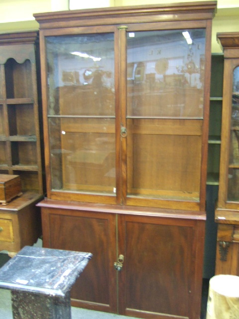 Appraisal: A George III mahogany bookcase cabinet the plain cornice above