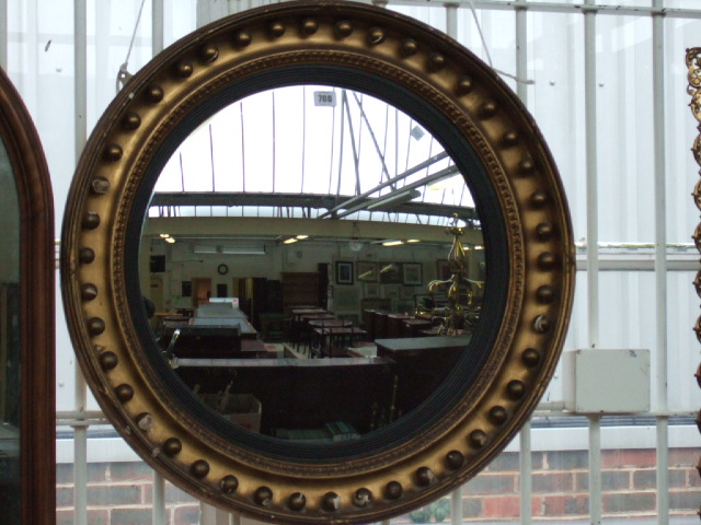 Appraisal: A th century gilt framed convex wall mirror with ball