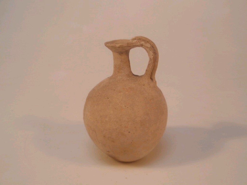 Appraisal: A small ancient pottery jug with a spherical body narrow