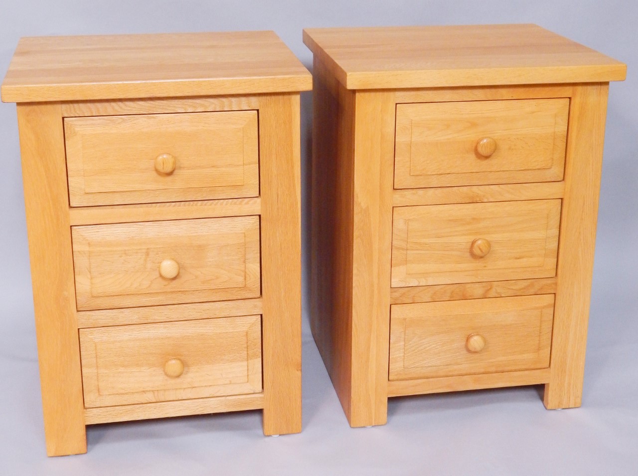 Appraisal: A pair of light oak three drawer bedside chests width