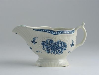 Appraisal: A Worcester strap fluted sauceboat painted in blue with flowers