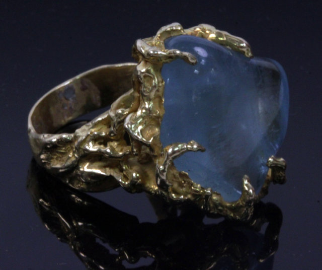 Appraisal: An aquamarine ring of modern design the smooth uncut aquamarine