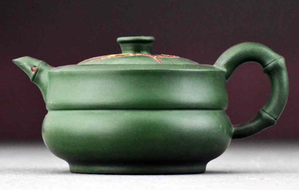 Appraisal: Chinese Yixing Pottery Tea PotWith slip decoration and bamboo spout