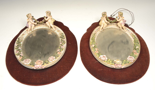 Appraisal: A PAIR OF GERMAN PORCELAIN OVAL HANGING WALL MIRRORS with