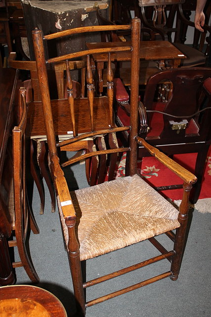 Appraisal: A COUNTRY ELM SPINDLE BACK ELBOW CHAIR with rush seat