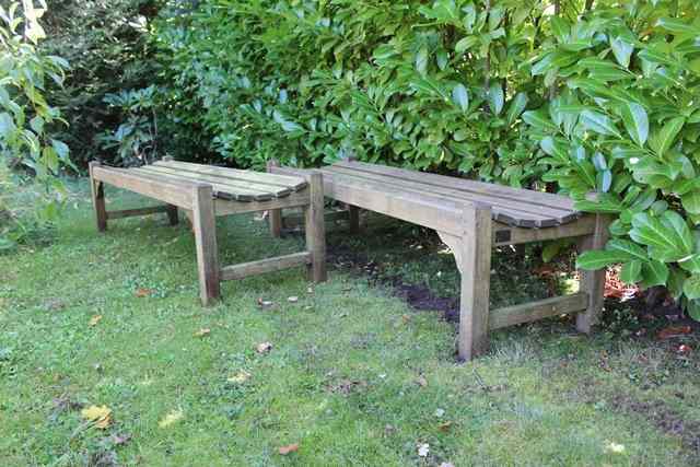 Appraisal: A PAIR OF TEAK GARDEN BENCHES each bearing a label