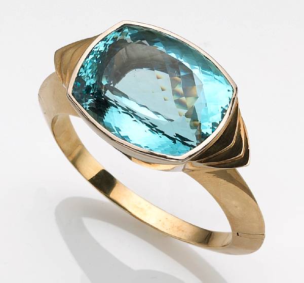 Appraisal: An aquamarine bangle bracelet featuring a cushion-shaped aquamarine measuring approximately