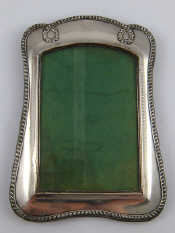 Appraisal: A silver faced strut back photo frame with looped ropework