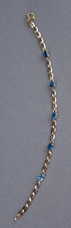 Appraisal: KT yellow gold London blue topaz bracelet Bracelet contains oval