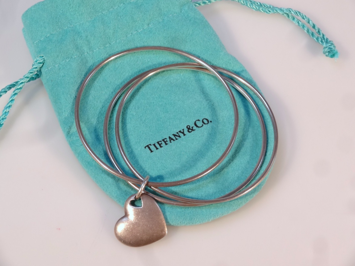 Appraisal: A Tiffany Co triple bangle with heart centre marked cm