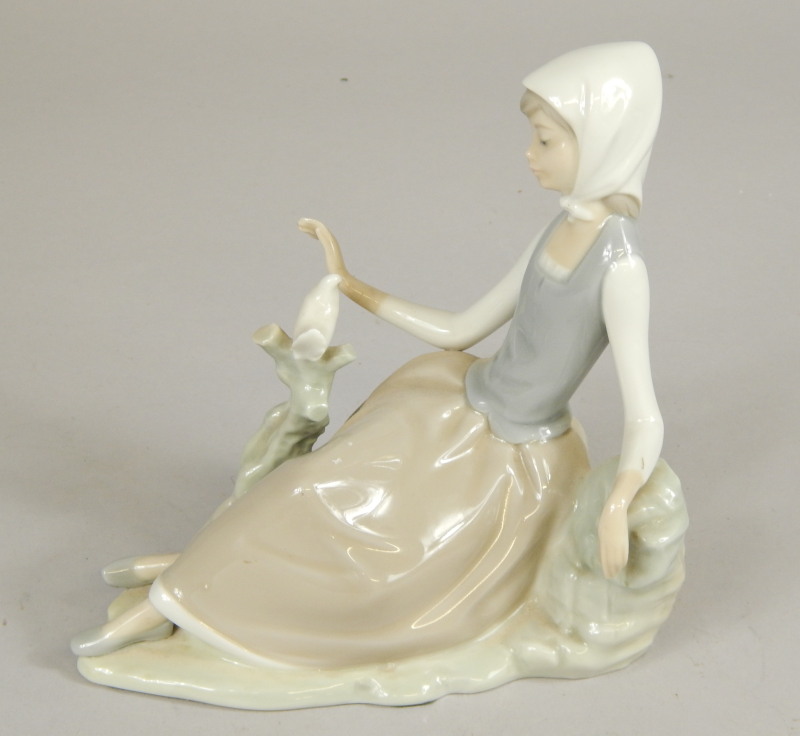 Appraisal: A Lladro model of a recumbent lady with a bird