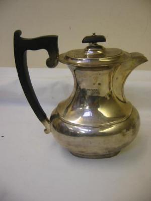 Appraisal: A HOT WATER JUG of oval baluster form with ebonised