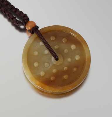 Appraisal: A Carved Jade Pendant on Chord Carved jade pendant in