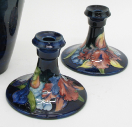 Appraisal: PAIR MOORCROFT GLAZED POTTERY CANDLESTICKS red floral design with blue