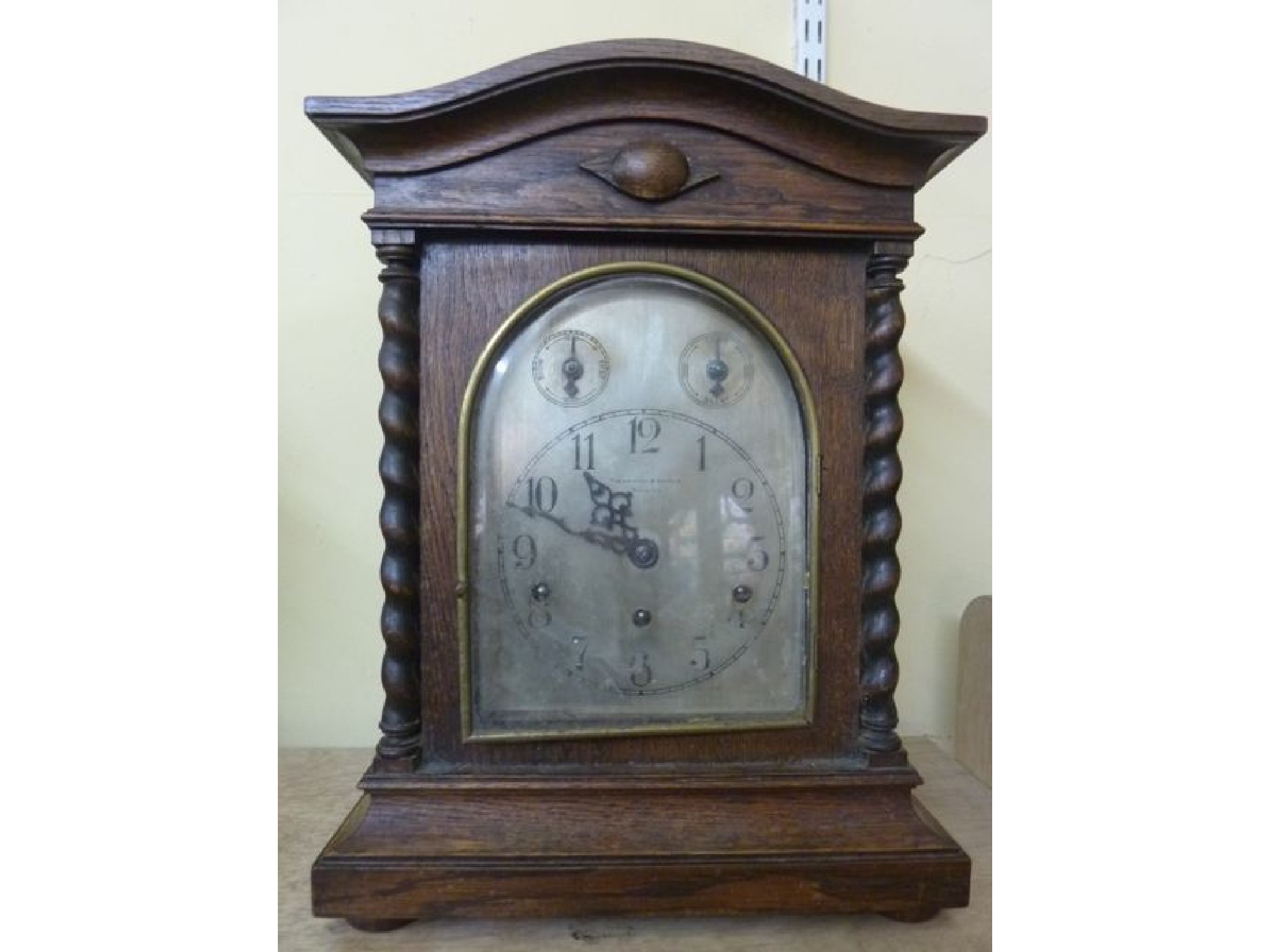 Appraisal: An Edwardian oak bracket clock with barley twist supports the