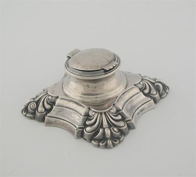 Appraisal: An Edwardian capstan inkwell on a scrolling stepped base by