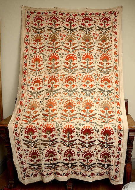 Appraisal: AN INDIAN EMBROIDERED TEXTILE WALL HANGING with stylised flower decoration