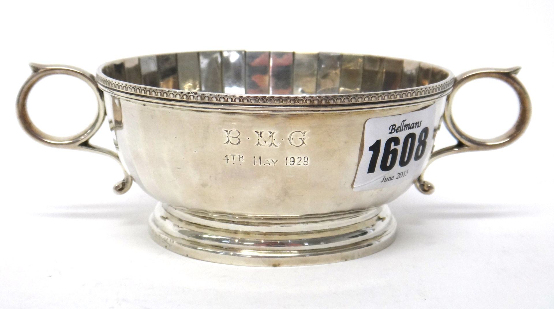 Appraisal: A silver twin handled christening bowl of panelled circular form