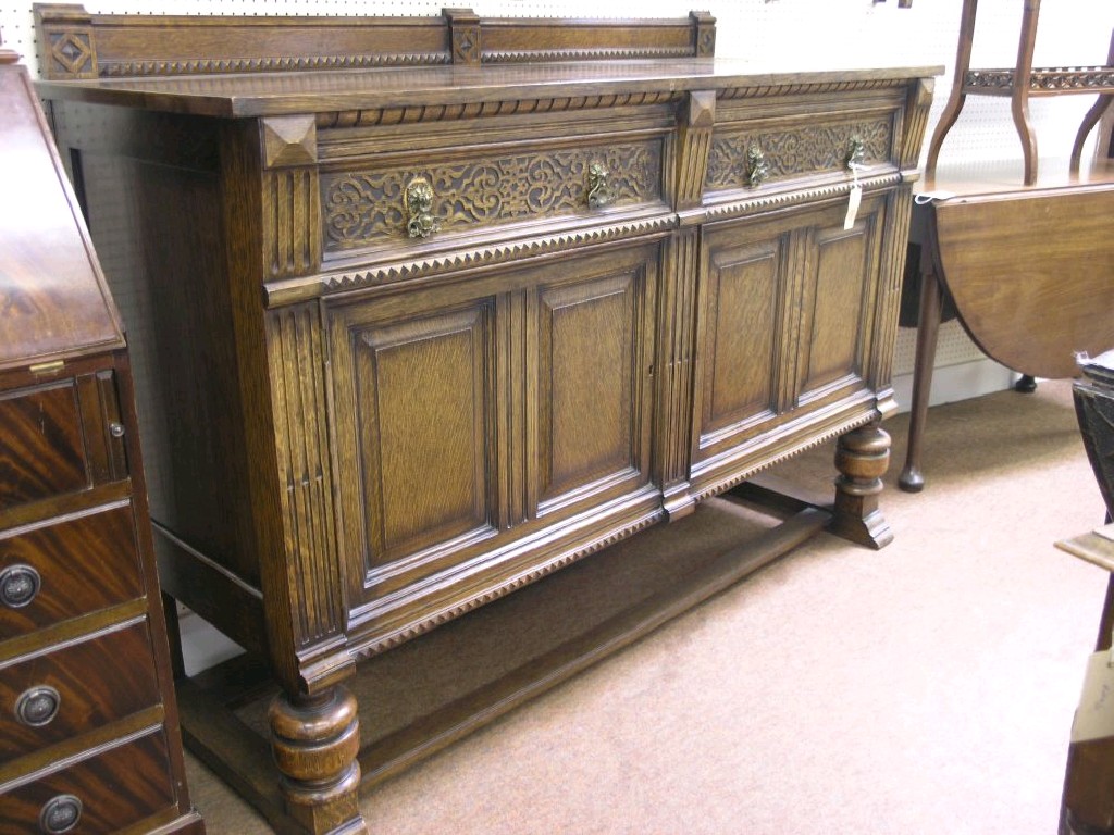 Appraisal: A 's solid dark oak sideboard pair of frieze drawers